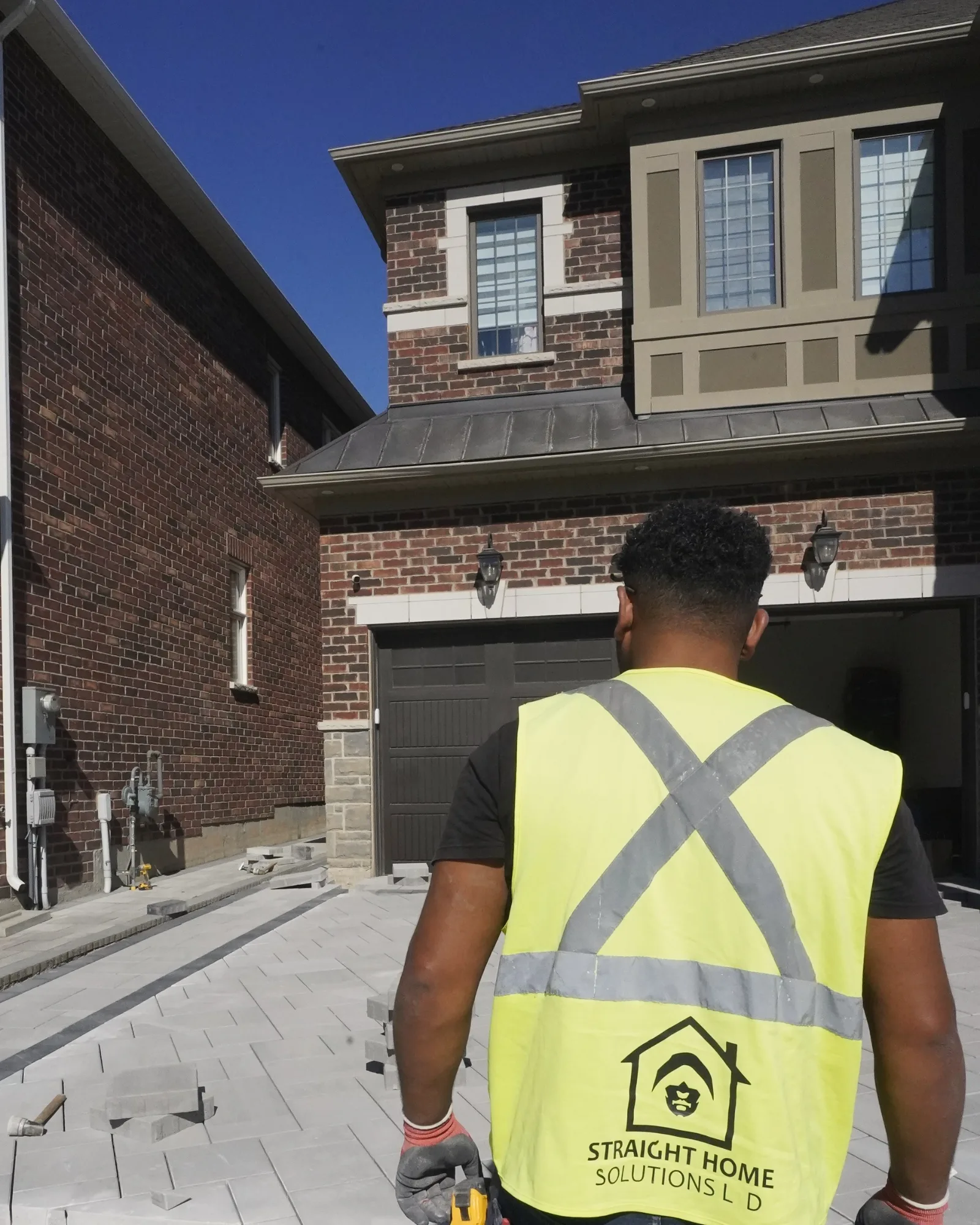 Straight Home Solutions crew member reviewing paver placement during installation